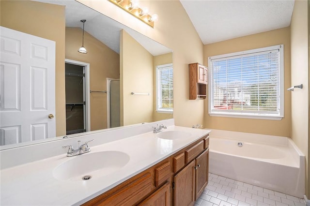 bathroom featuring vaulted ceiling, a garden tub, a sink, and tile patterned floors