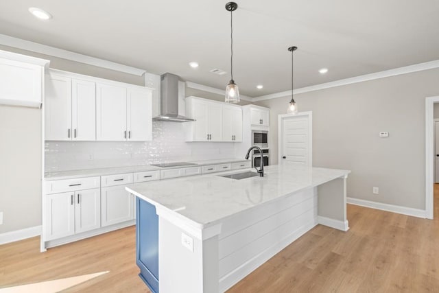 kitchen featuring a sink, stainless steel microwave, wall chimney exhaust hood, and white cabinetry