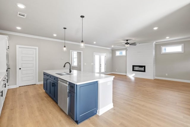 kitchen featuring visible vents, ornamental molding, a sink, a fireplace, and dishwasher