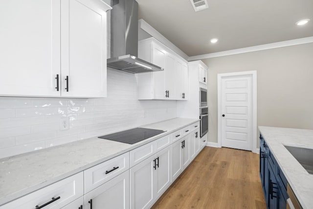 kitchen featuring visible vents, tasteful backsplash, white cabinets, wall chimney range hood, and black electric cooktop