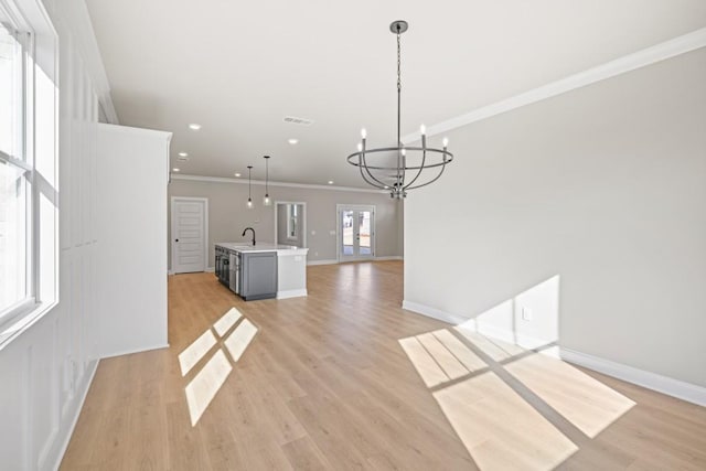 unfurnished dining area with baseboards, light wood-style floors, an inviting chandelier, and ornamental molding