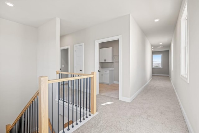 hall with an upstairs landing, recessed lighting, baseboards, and carpet