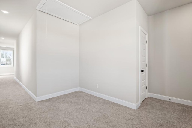 carpeted empty room with recessed lighting, attic access, and baseboards