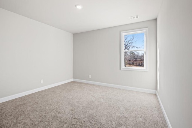 carpeted spare room featuring baseboards and visible vents