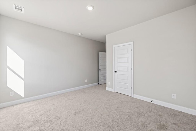 empty room with visible vents, carpet floors, and baseboards