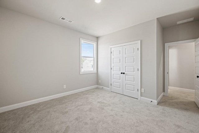 unfurnished bedroom featuring visible vents, baseboards, a closet, and carpet flooring