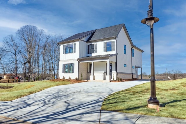 view of front of home with brick siding, concrete driveway, and a front lawn