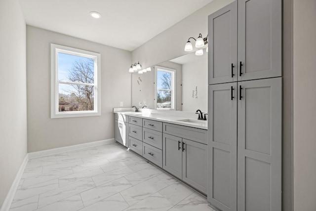 full bath featuring a sink, baseboards, and marble finish floor