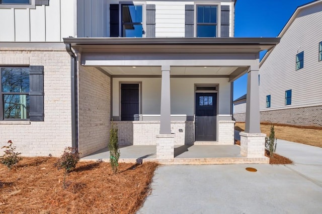 property entrance with brick siding and board and batten siding