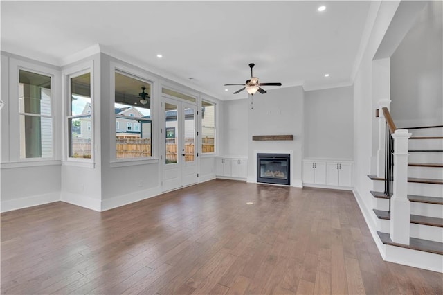unfurnished living room featuring ceiling fan, hardwood / wood-style flooring, and crown molding