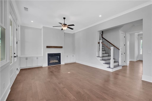 unfurnished living room featuring ceiling fan, crown molding, and hardwood / wood-style floors