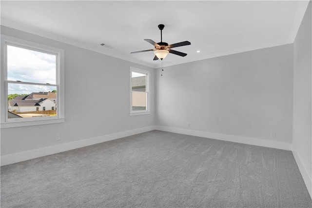 empty room featuring carpet floors, ceiling fan, and crown molding