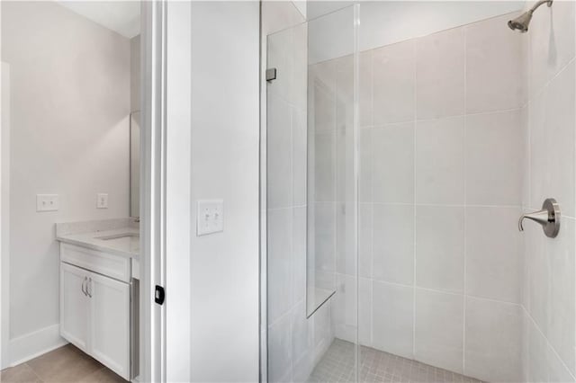 bathroom with walk in shower, vanity, and tile patterned floors