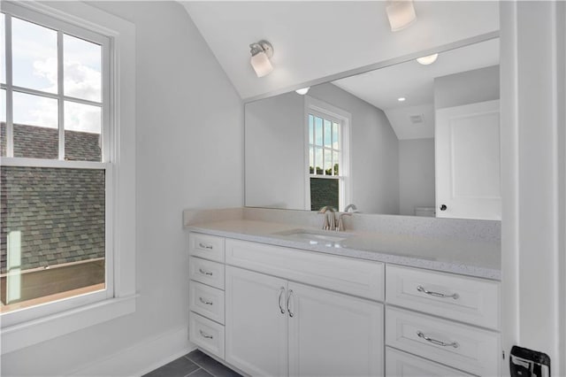 bathroom featuring toilet, vanity, lofted ceiling, and tile patterned flooring