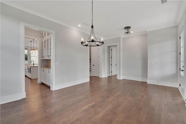 unfurnished dining area with sink, dark hardwood / wood-style flooring, and a notable chandelier