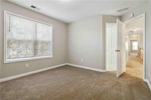 carpeted spare room featuring plenty of natural light