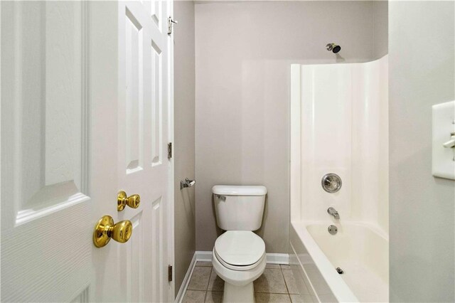 bathroom with tile patterned flooring, toilet, and washtub / shower combination