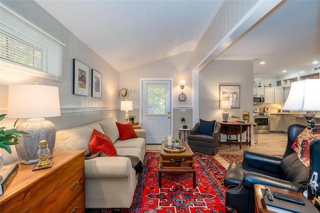 living room featuring light hardwood / wood-style floors, plenty of natural light, and vaulted ceiling