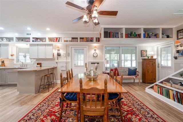 dining area with ceiling fan, sink, and light hardwood / wood-style floors