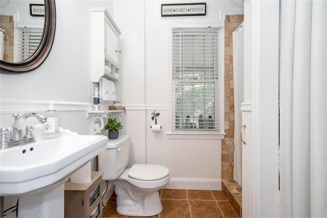 bathroom with toilet, a shower with shower curtain, sink, and tile patterned floors