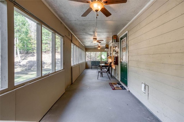 unfurnished sunroom with ceiling fan