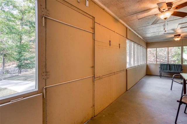 unfurnished sunroom with ceiling fan