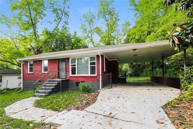 view of front of house featuring brick siding, driveway, and a carport