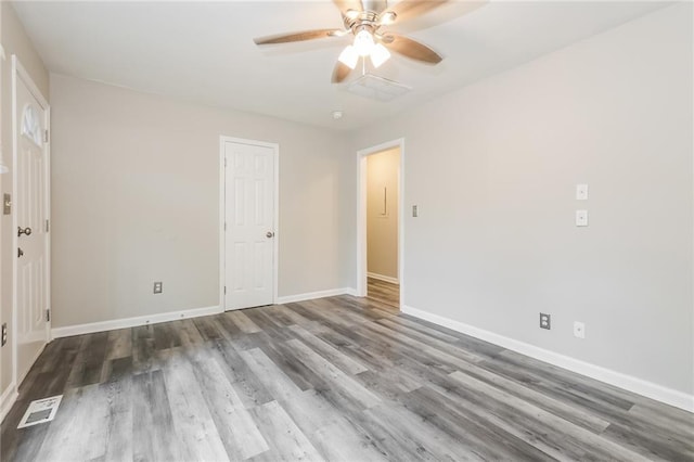 unfurnished bedroom with visible vents, a ceiling fan, baseboards, and wood finished floors