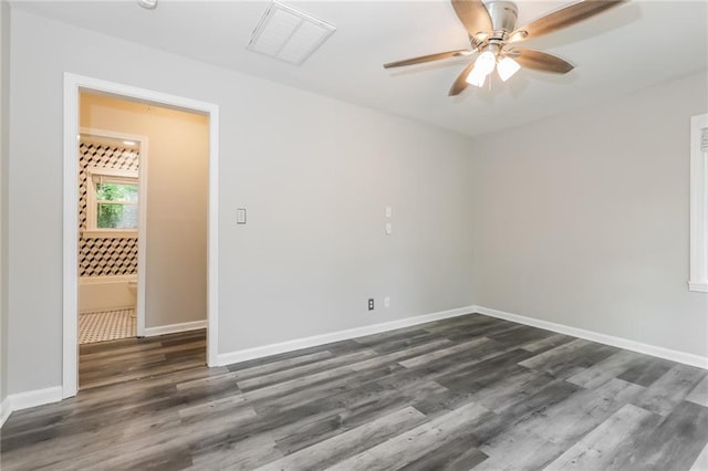 unfurnished room featuring visible vents, a ceiling fan, dark wood finished floors, and baseboards