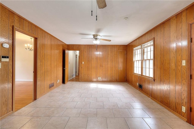 unfurnished room featuring wooden walls and ceiling fan