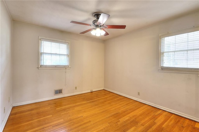 spare room with ceiling fan and light wood-type flooring