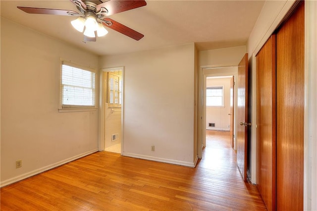 empty room with ceiling fan and light wood-type flooring