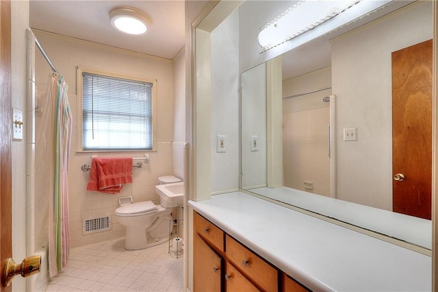 bathroom featuring walk in shower, tile patterned floors, toilet, tile walls, and vanity