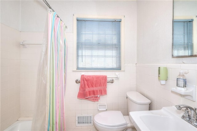 full bathroom with shower / bath combination with curtain, toilet, sink, and tile walls