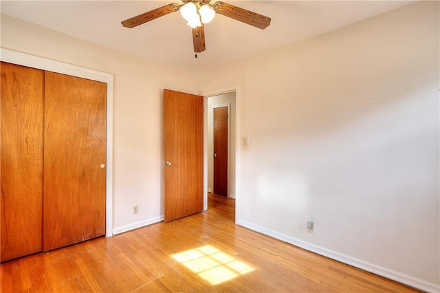 unfurnished bedroom featuring light hardwood / wood-style floors, a closet, and ceiling fan