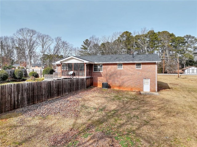 back of house with cooling unit, a yard, and a sunroom