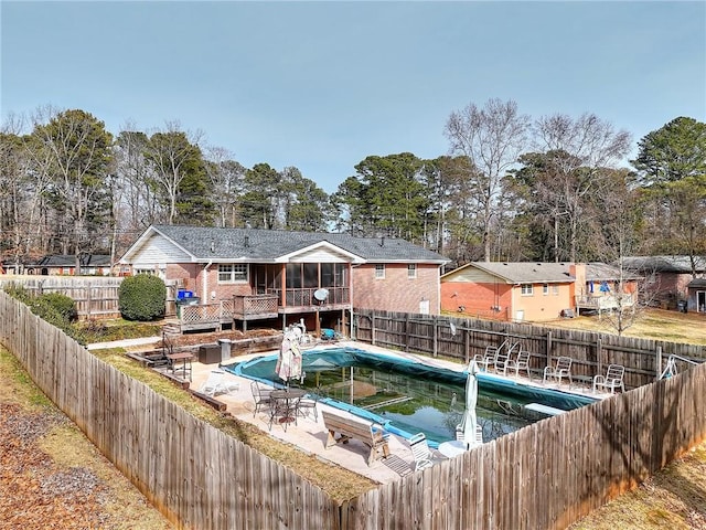 view of pool featuring a patio, a sunroom, and a deck