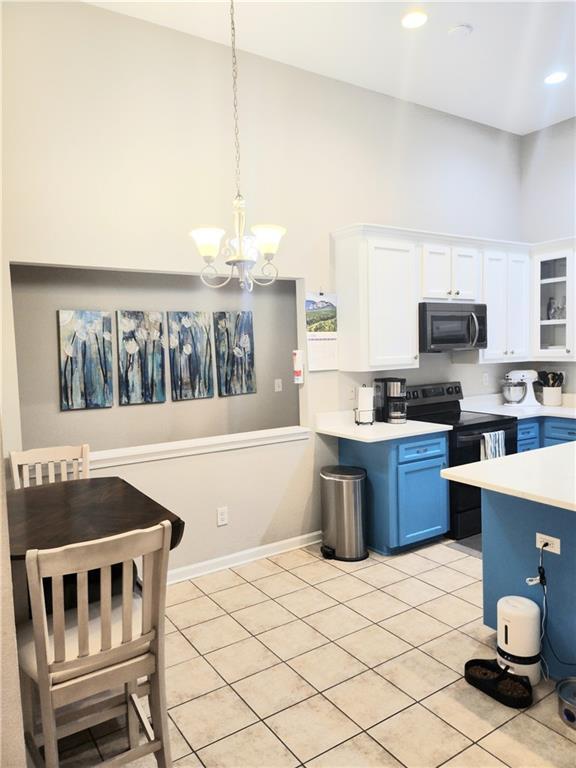 3473 Newtons Crest Cir, Snellville, GA 30078 - kitchen with electric range, light countertops, white cabinetry, blue cabinetry, and a high ceiling