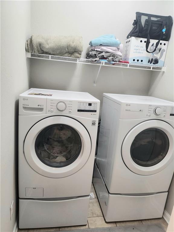 3473 Newtons Crest Cir, Snellville, GA 30078 - laundry area with independent washer and dryer and light tile patterned flooring