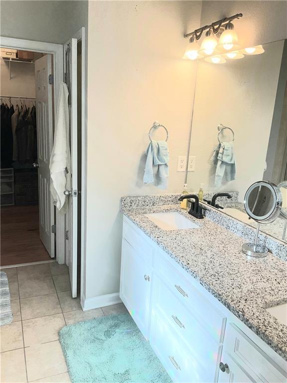 3473 Newtons Crest Cir, Snellville, GA 30078 - bathroom with double vanity, a walk in closet, and tile patterned flooring