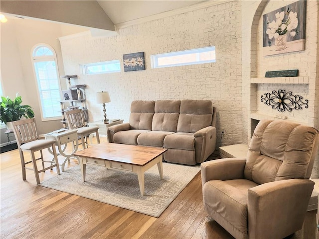 3473 Newtons Crest Cir, Snellville, GA 30078 - living room with brick wall, light wood-style floors, and lofted ceiling