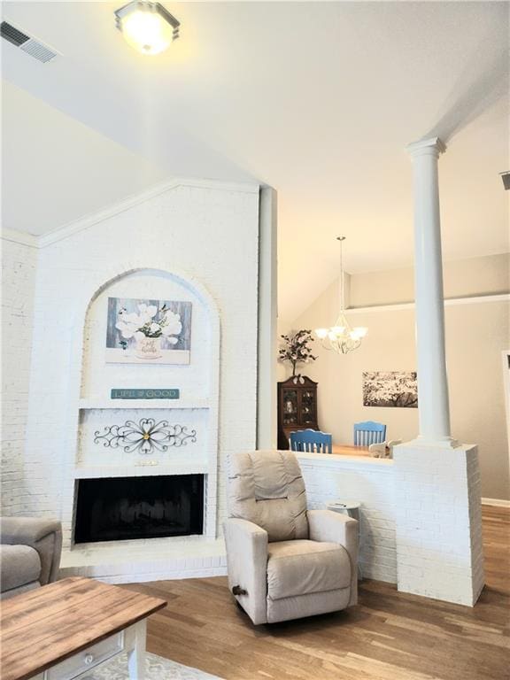 3473 Newtons Crest Cir, Snellville, GA 30078 - living room with wood finished floors, a chandelier, vaulted ceiling, a fireplace, and decorative columns