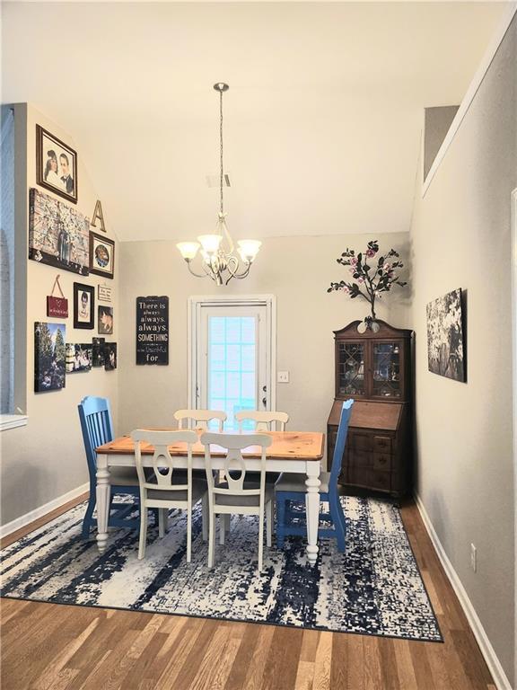 3473 Newtons Crest Cir, Snellville, GA 30078 - dining area with a chandelier, wood finished floors, and lofted ceiling
