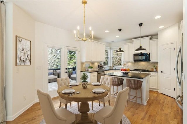 dining area with an inviting chandelier, light wood-style flooring, baseboards, and recessed lighting