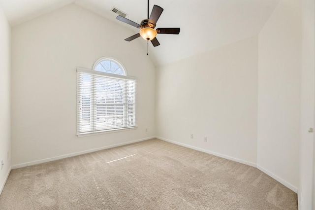 spare room with light colored carpet, visible vents, lofted ceiling, and baseboards