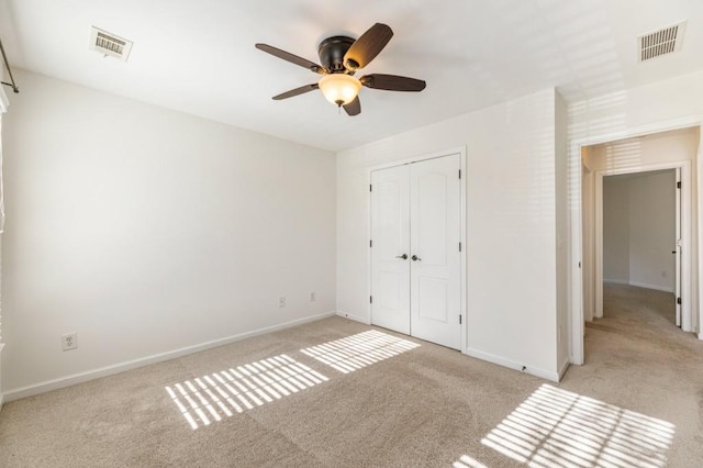 unfurnished bedroom featuring light colored carpet, a closet, visible vents, and baseboards