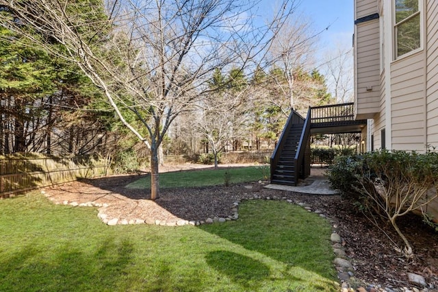 view of yard featuring fence and stairs