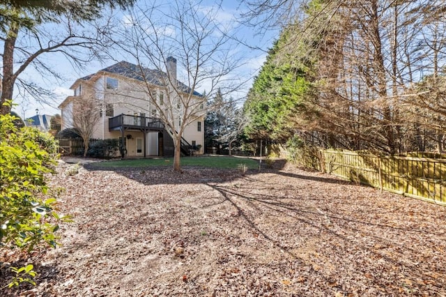 back of property featuring a deck, a chimney, and fence