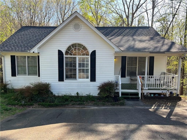 single story home featuring a porch and a shingled roof