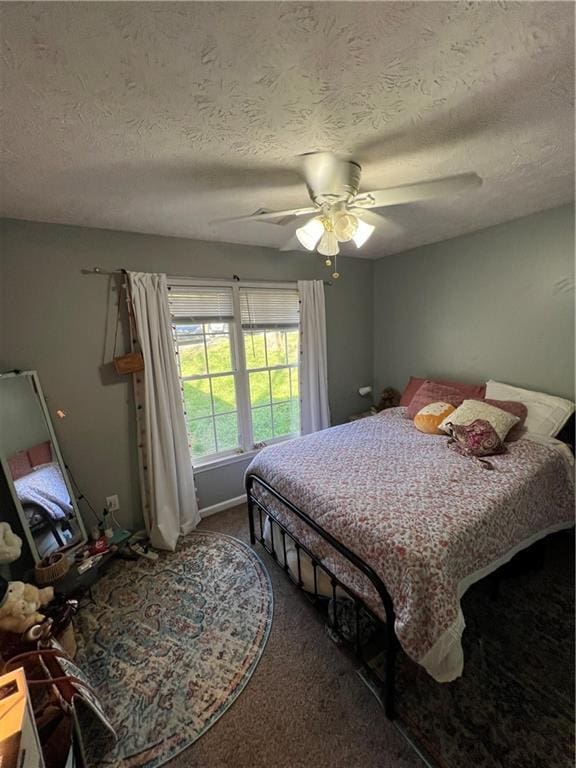 bedroom with carpet, a textured ceiling, and a ceiling fan